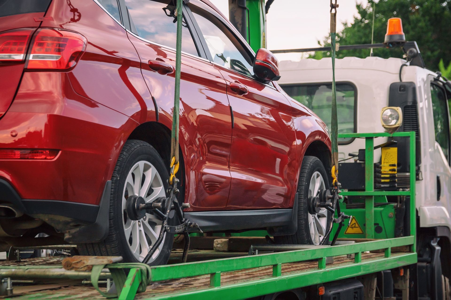 Red Car Being Towed on a Green Flatbed Truck — Downs Towing & Recovery Service in Miles, QLD