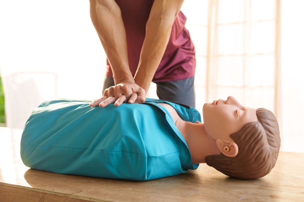 Person performing CPR on a training mannequin.