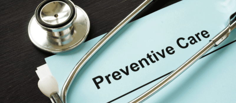 A stethoscope is sitting on top of a piece of paper that says preventive care