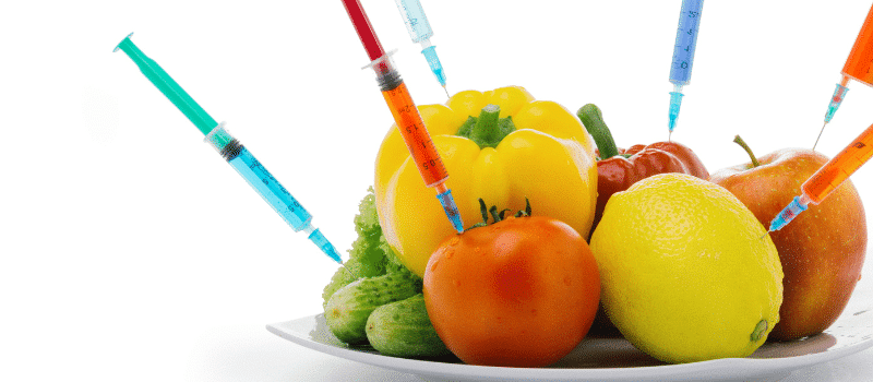 A plate of fruits and vegetables with syringes in them.