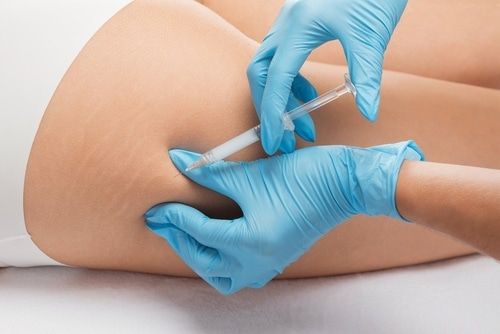 A woman is getting an injection in her leg.