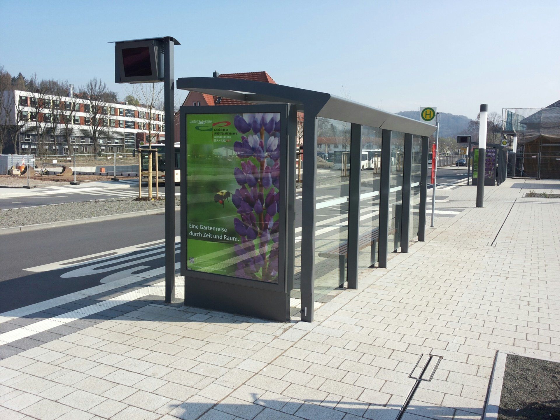 Eine Bushaltestelle mit einem Schild mit lila Blumen darauf