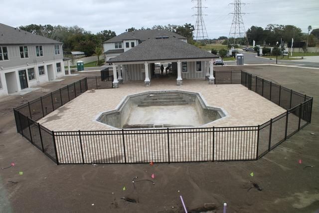 Black aluminum fence around community pool.