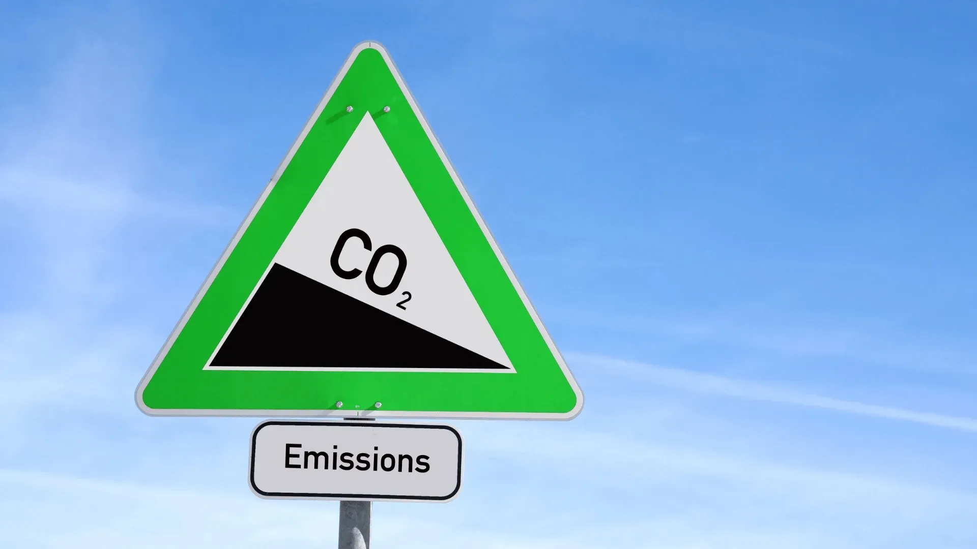 A green and white triangle sign that says emissions on it.