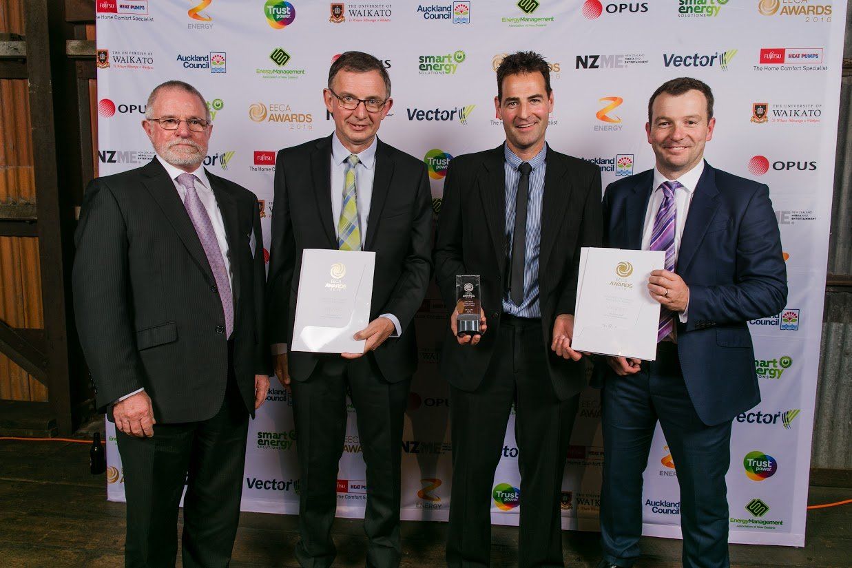 a group of men in suits and ties are standing next to each other holding awards .
