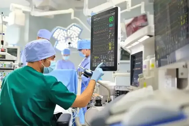 a surgeon is looking at a monitor in an operating room .