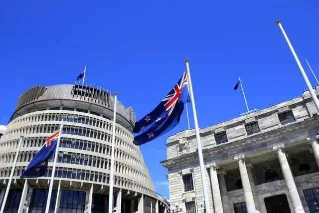 two flags are flying in front of a building
