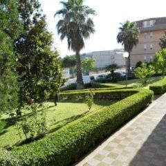 area verde con siepi, prato e sentiero centrale