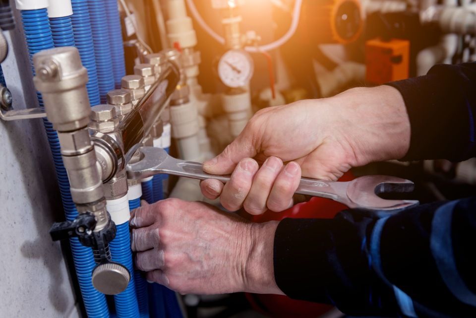 Heating engineer installing modern heating system in boiler room