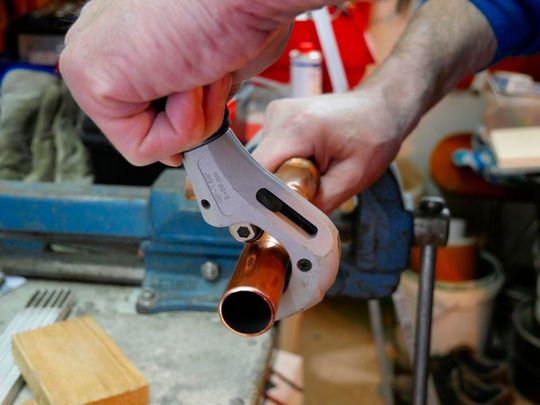 Plumber cutting a copper pipe