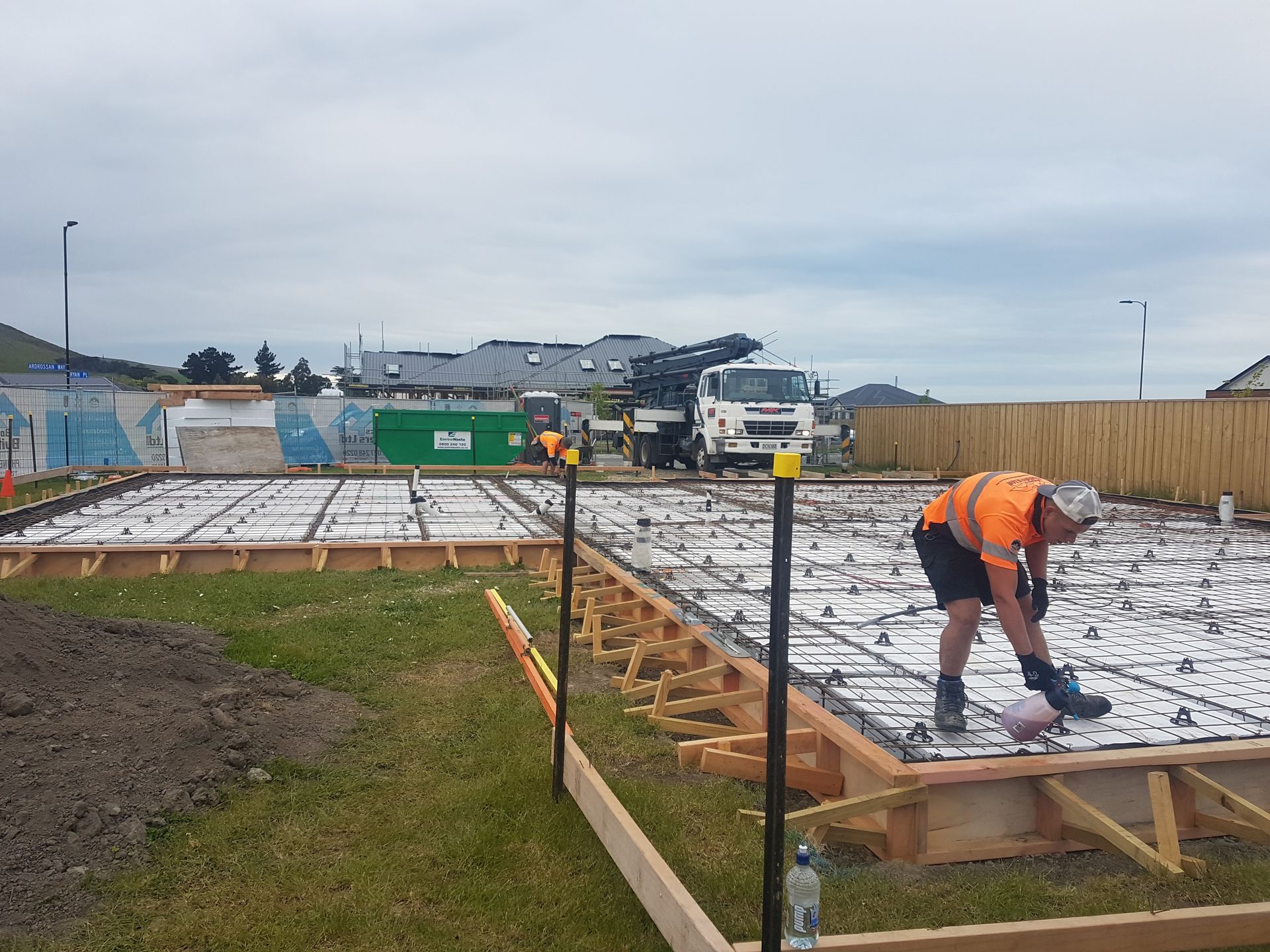 A man is working on a concrete slab at a construction site.