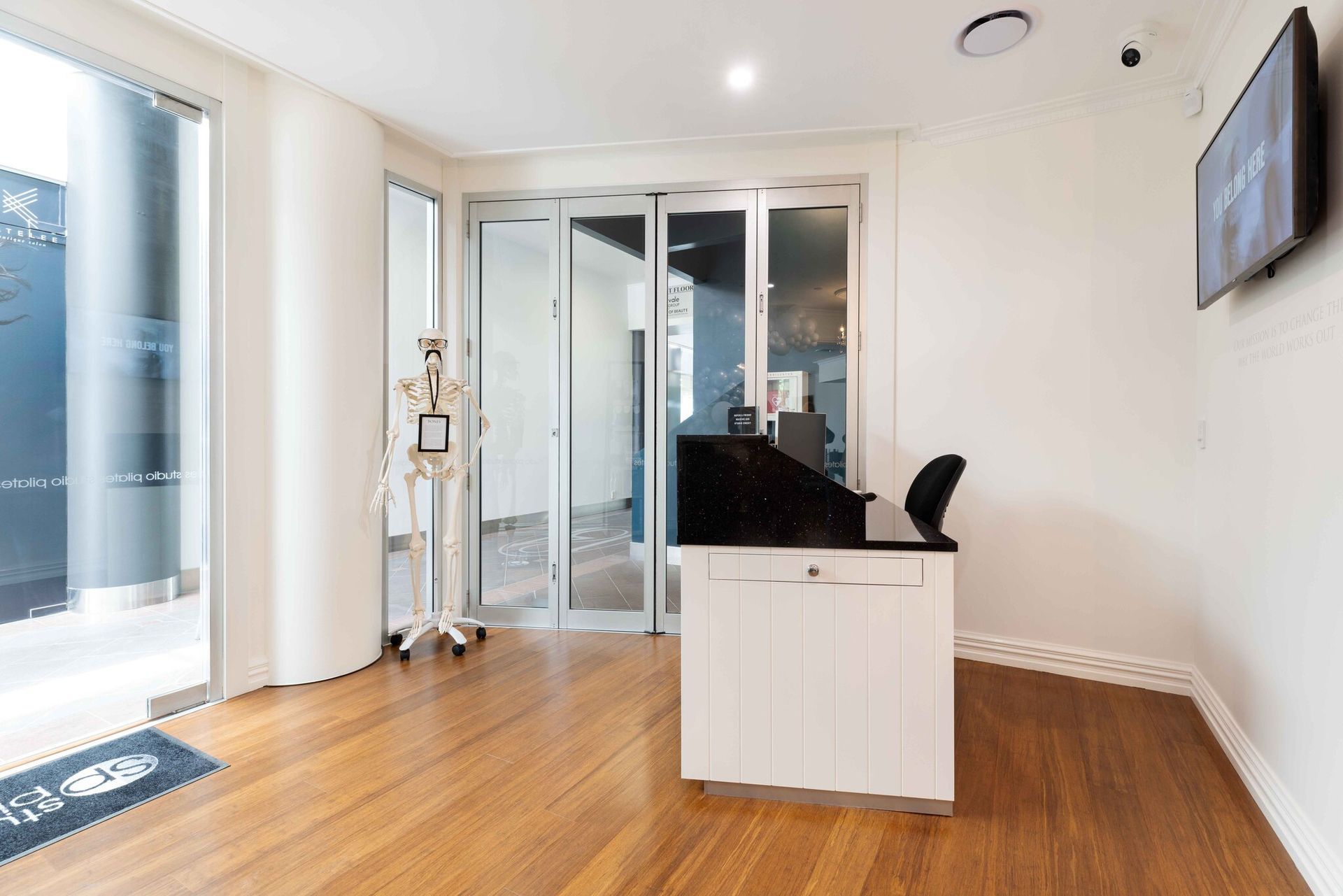 A reception area in a building with a desk and a television.