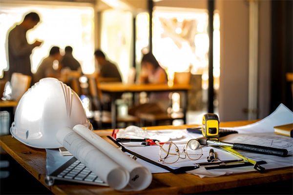 A hard hat is sitting on top of a wooden table.