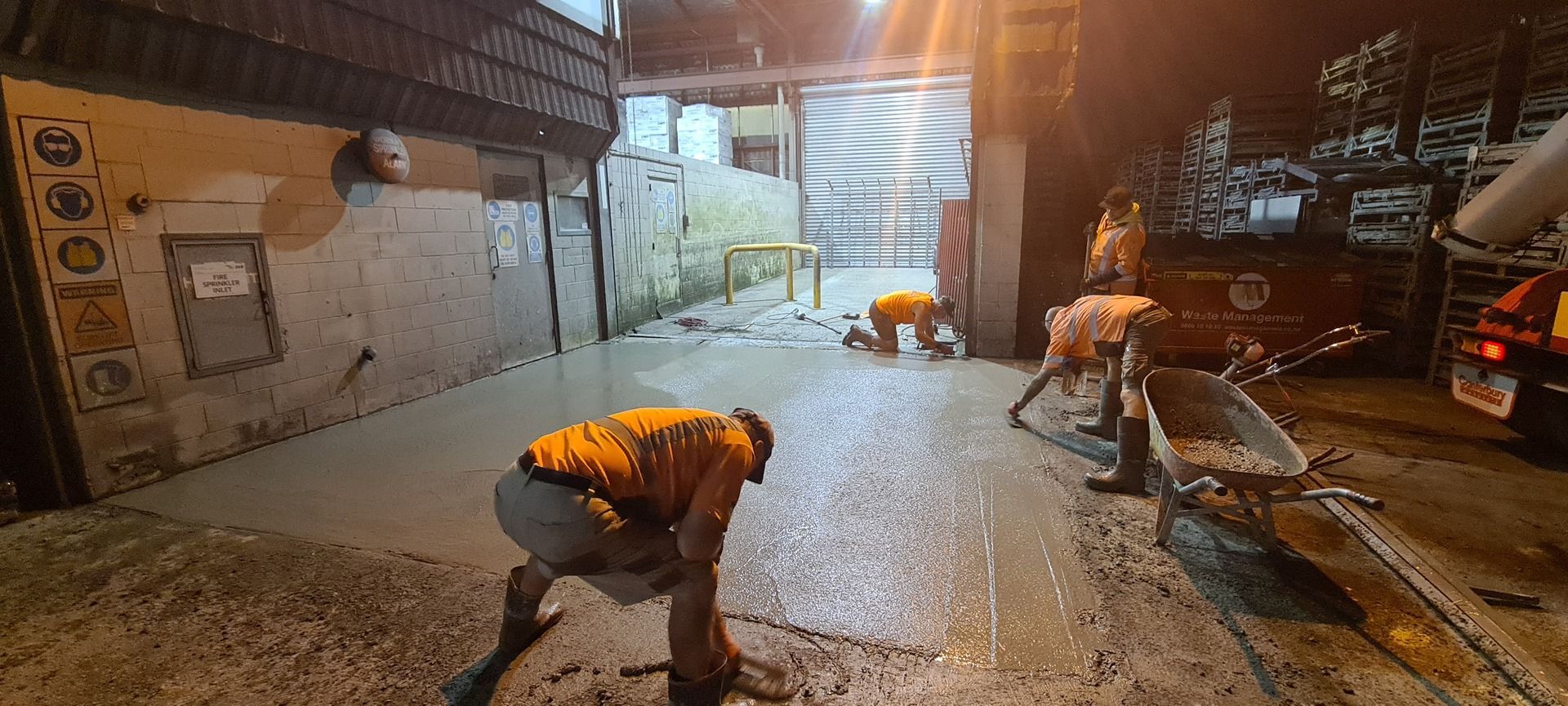 A group of people are working on a street at night.