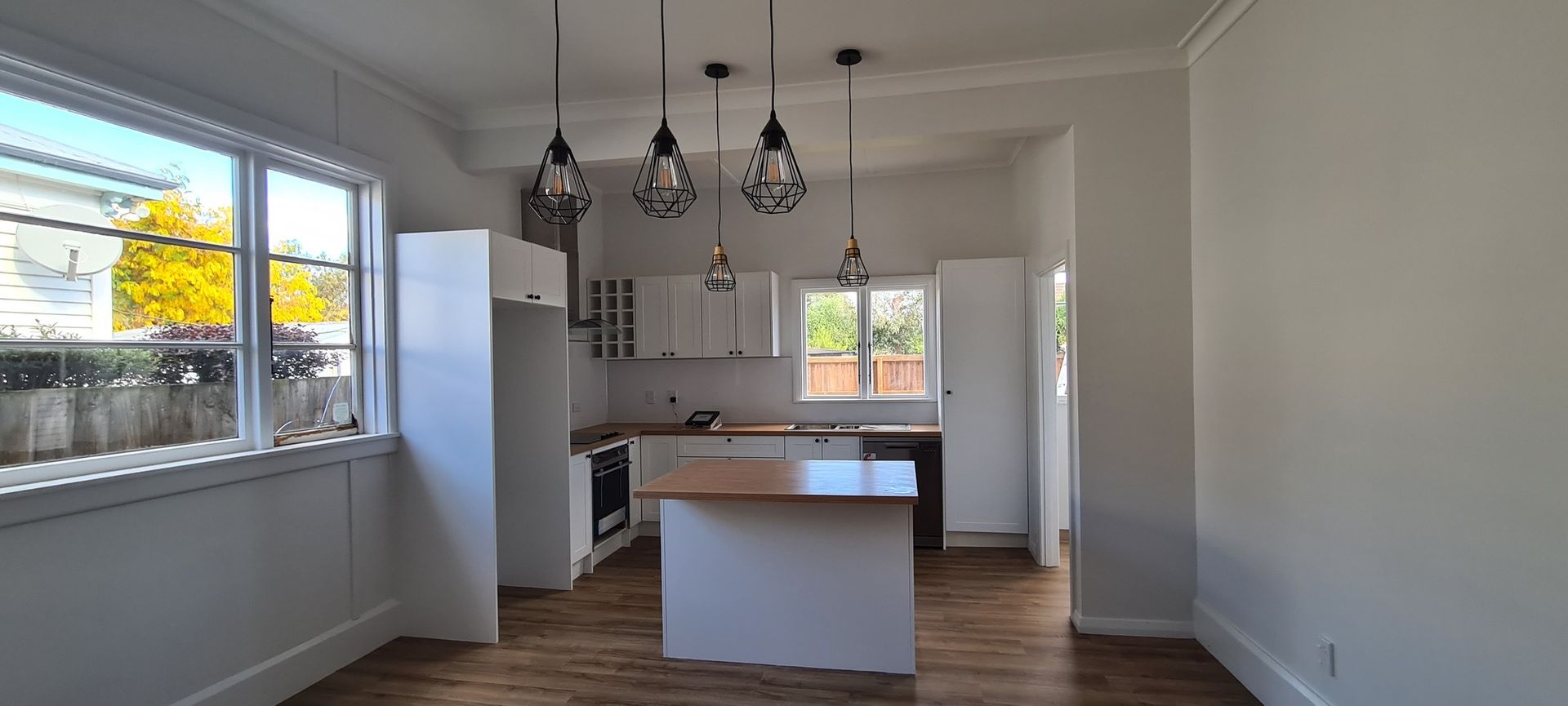 An empty kitchen with a large island in the middle of the room.