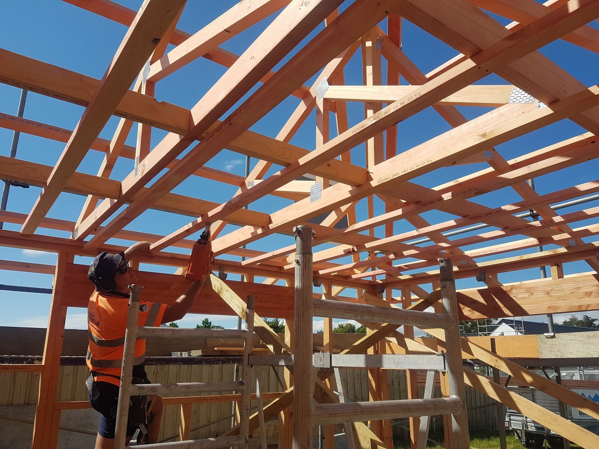 A man is working on the roof of a house under construction.