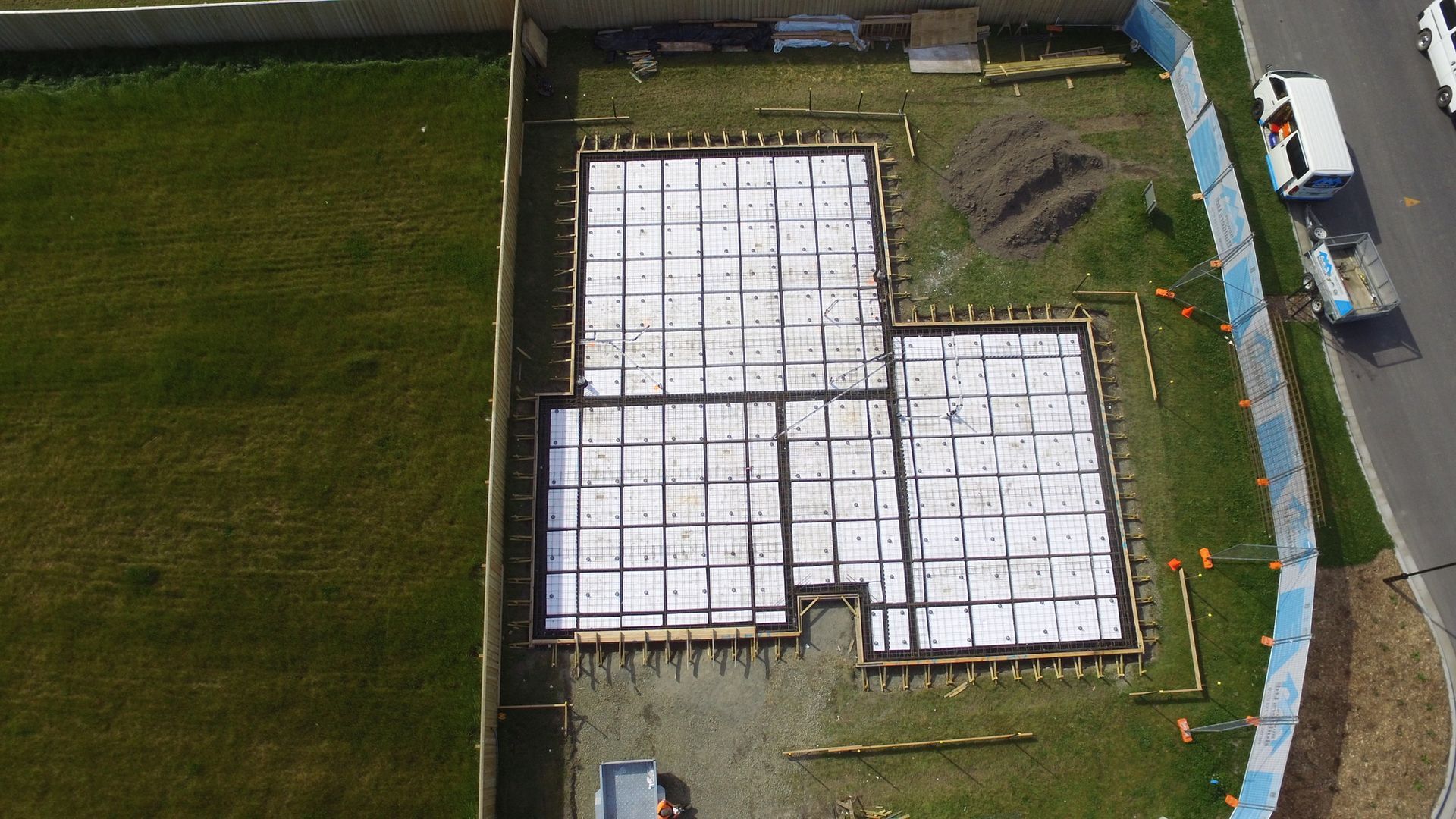 An aerial view of a house being built on a lush green field.