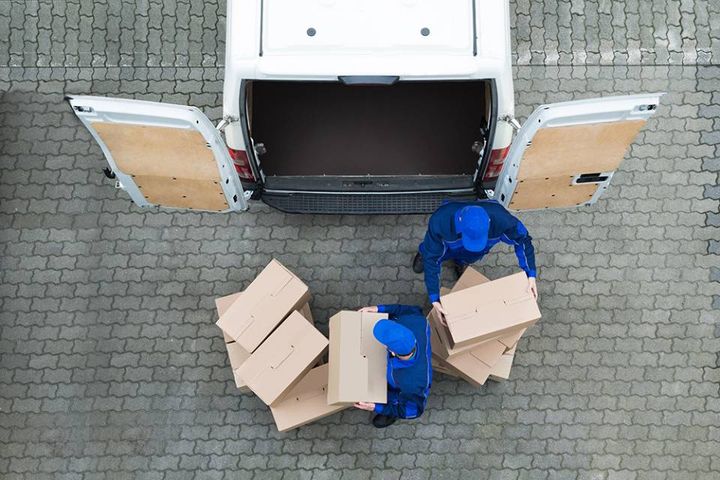 operatori mentre sistemano alcuni scatoloni in un furgone