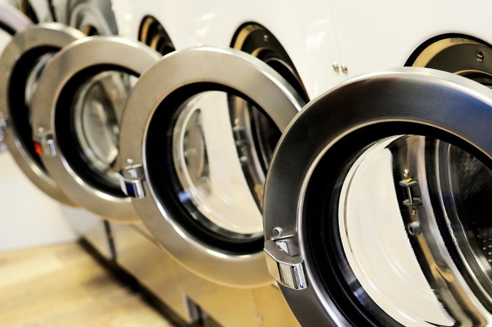 A Row Of Washing Machines Are Lined Up In A Laundromat — WashFold Laundromat In  Allenstown, QLD