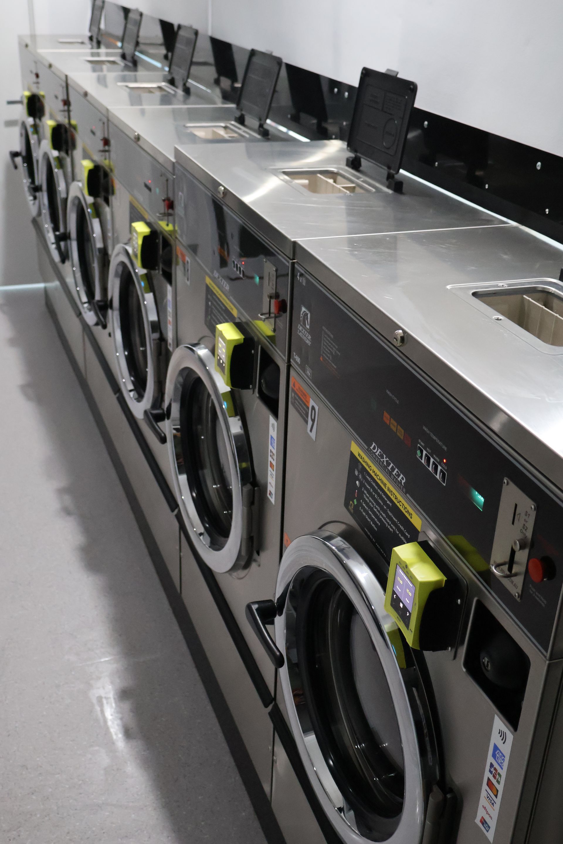 A Line Of Washing Machines At A Laundromat — WashFold Laundromat In  Allenstown, QLD