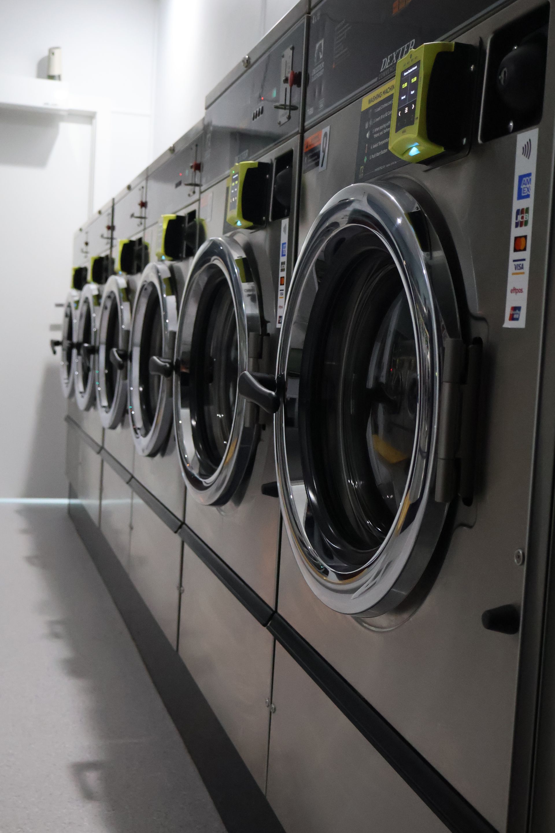 A Line Of Washing Machines At A Laundromat — WashFold Laundromat In  Allenstown, QLD