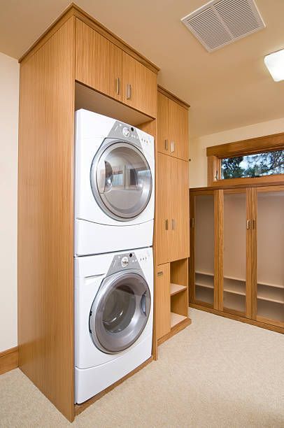 Stacked washer and dryer in built-in wooden cabinet. 