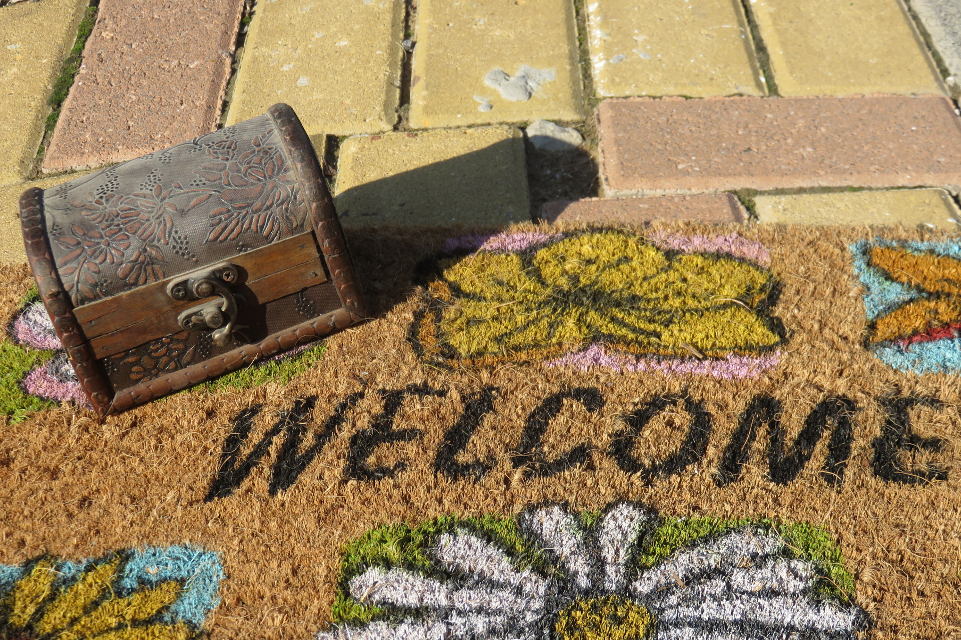 A welcome mat with a treasure chest on top of it