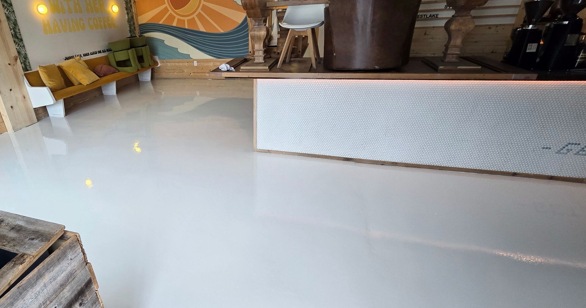 A white floor in a room with a painting on the wall.