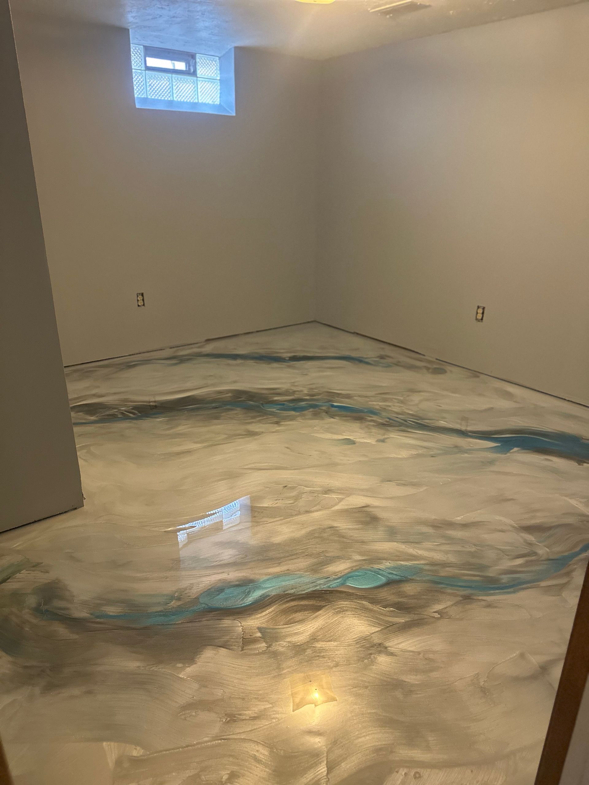 A room with a concrete floor and a window.