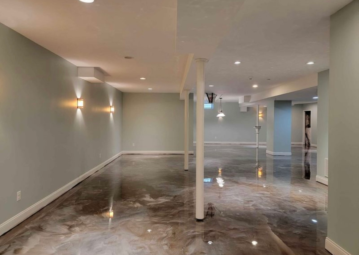 An empty basement with a shiny concrete floor and walls.