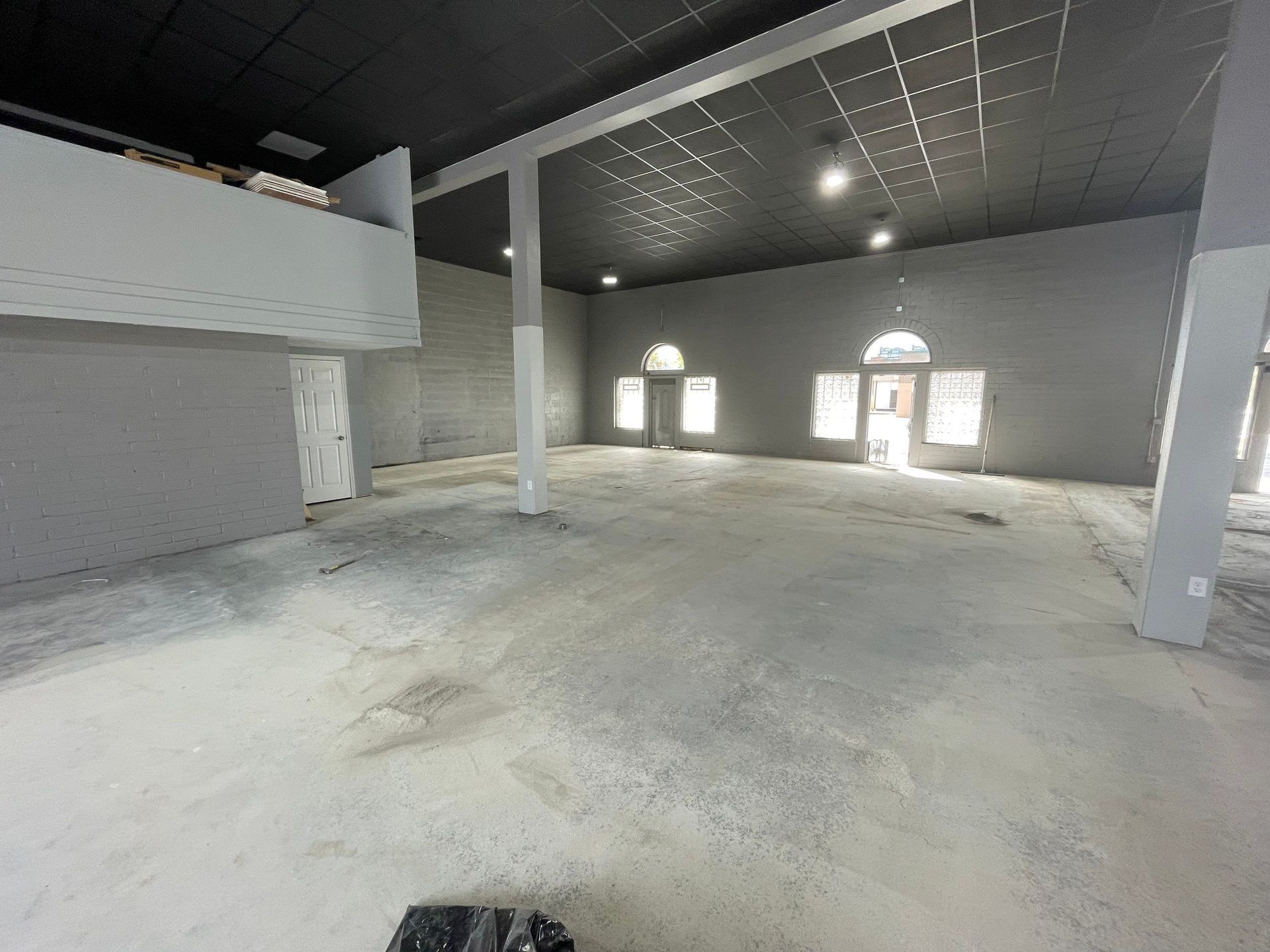 A large empty room with a balcony and a lot of windows.