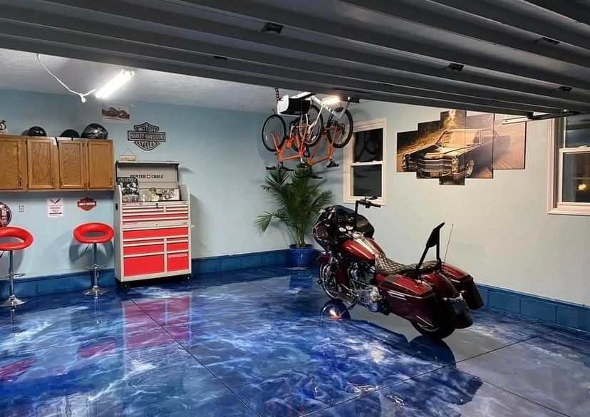 A motorcycle is parked in a garage with a blue floor.