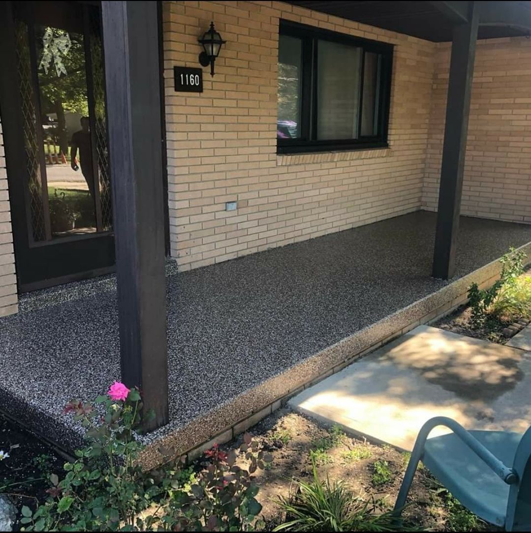 A brick house with a porch and a chair in front of it