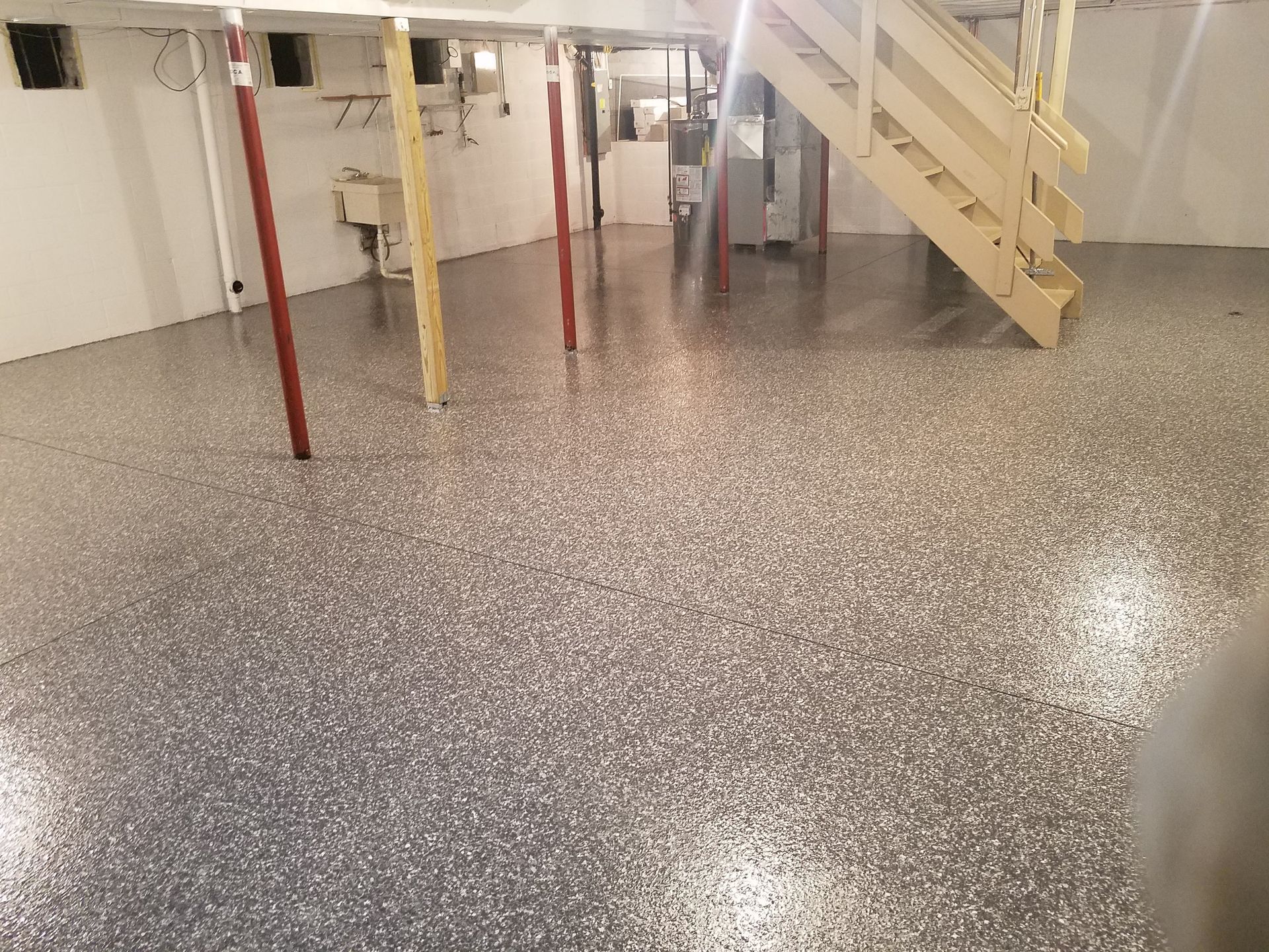 A basement with a staircase and a concrete floor.