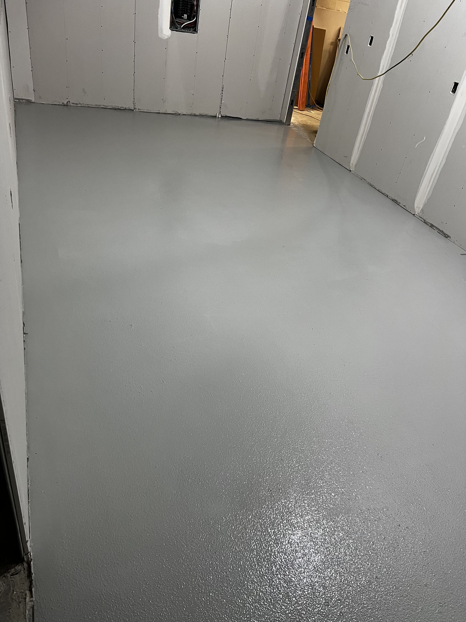 A room with a gray floor and white walls.