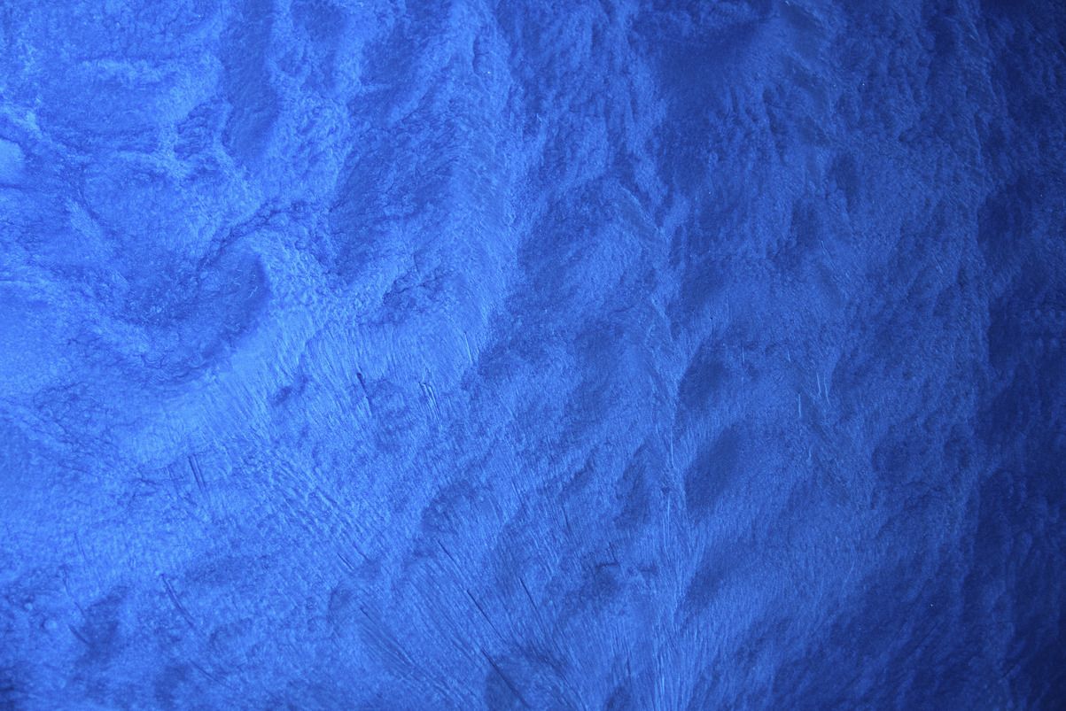 A close up of a blue wall with a texture.