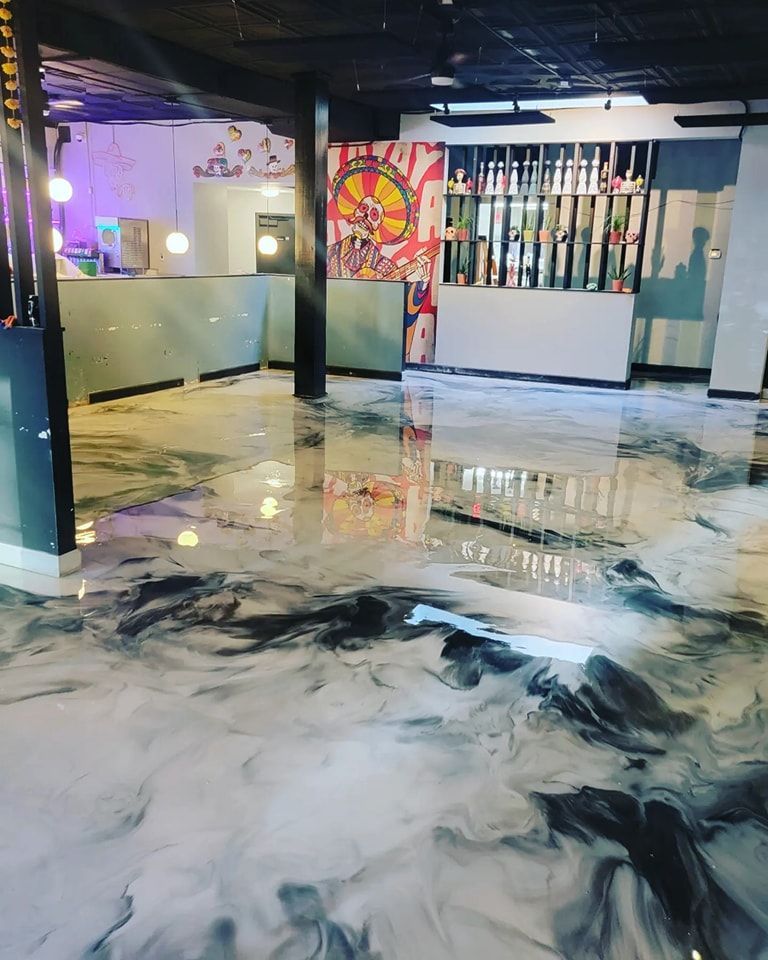 A large room with a marble floor and a painting on the wall.