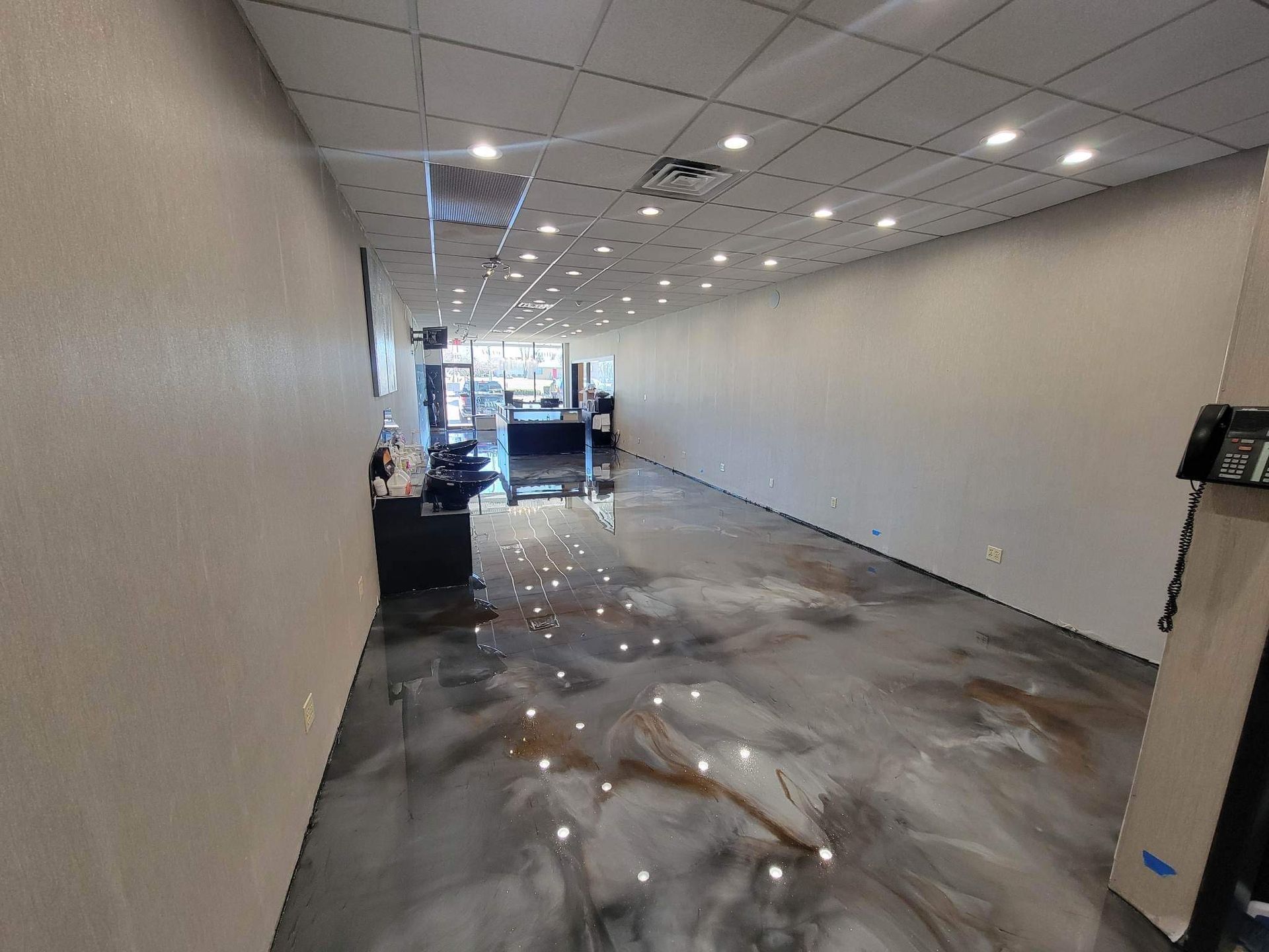 A large empty room with a metallic floor and white walls.