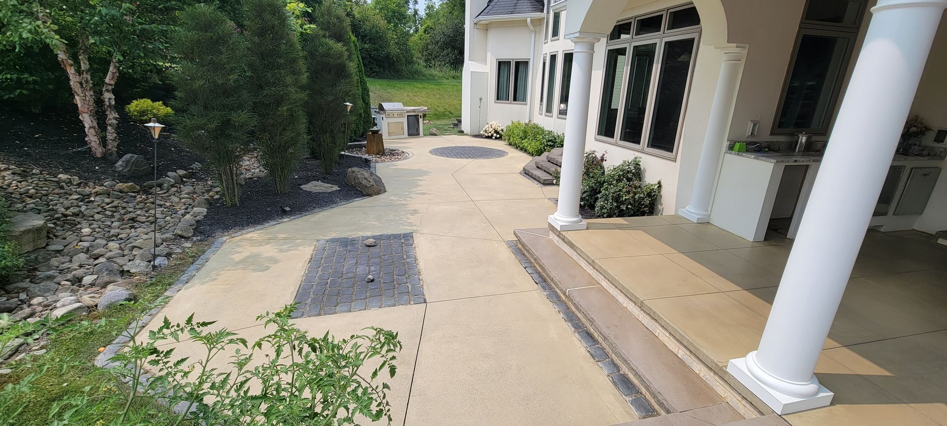 A large white house with a porch and a walkway leading to it.