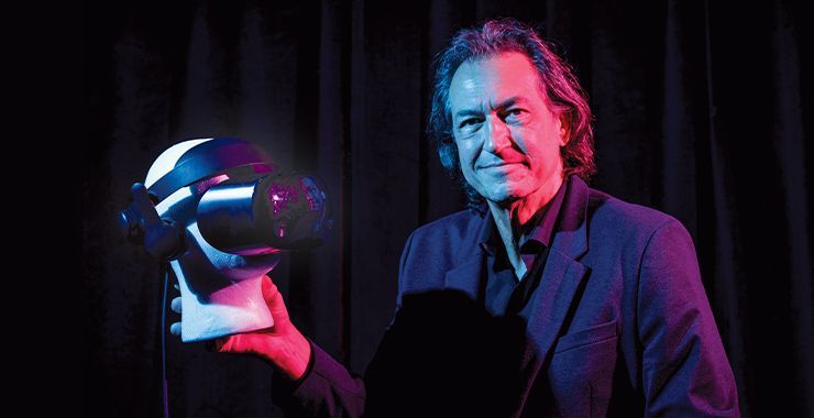 a man in a suit is holding a virtual reality headset