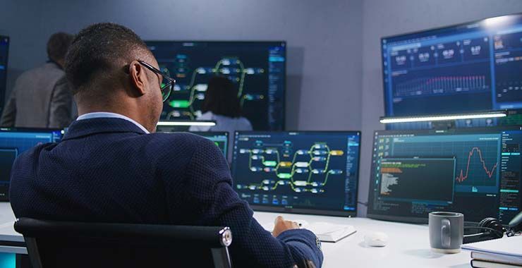 a man is sitting at a desk in front of a computer monitor .