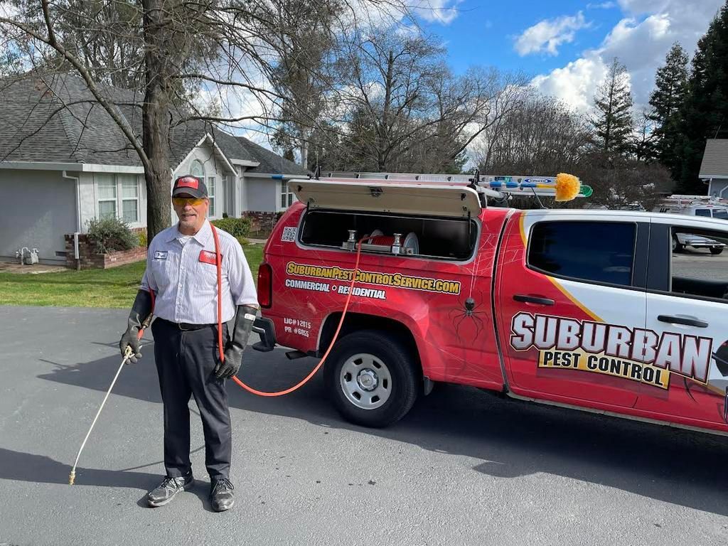 a man standing next to a suburban pest control truck