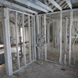 The inside of a building under construction with a lot of white framing.