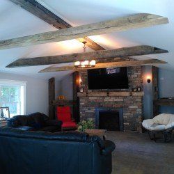 A living room with a fireplace , couch , chair and television.