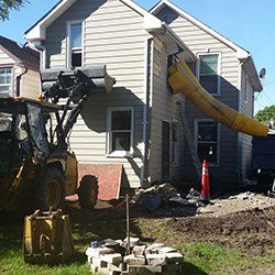 A yellow slide is coming out of the side of a house.