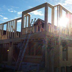 A house is being built with a ladder on top of it.
