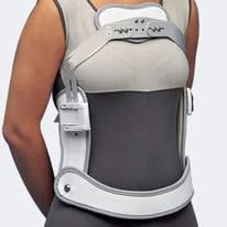 Una persona che indossa un tutore ortopedico rigido toraco-lombo-sacrale (TLSO) sopra una maglietta di colore chiaro.