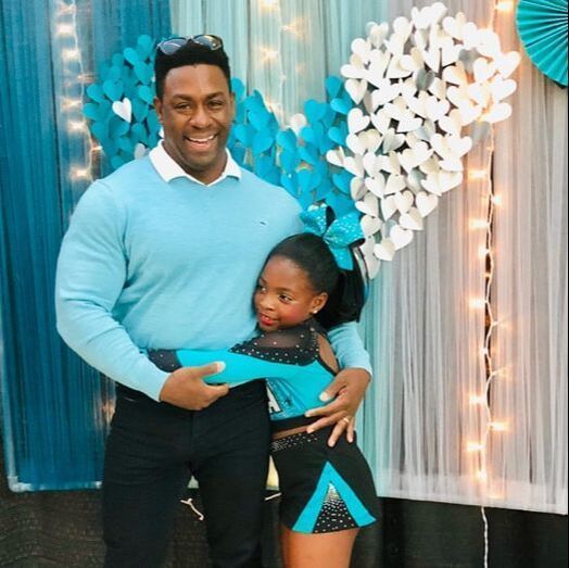 A man and a little girl are posing for a picture