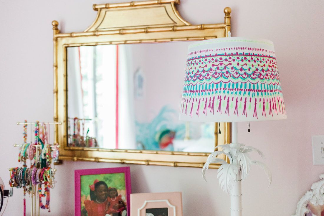 A lamp is sitting in front of a mirror in a room.