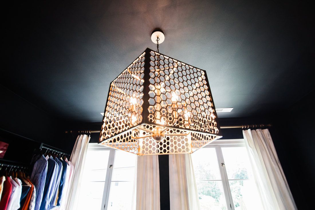 A chandelier is hanging from the ceiling in a closet.